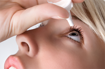 Woman using eye drops